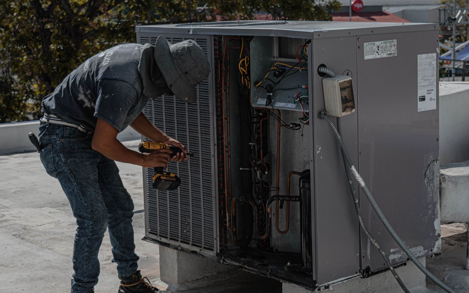 HVAC technician servicing an outdoor AC unit (stock photo)